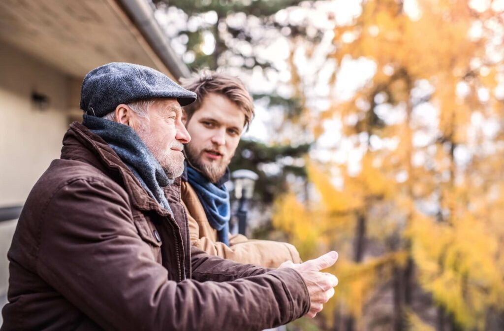 An adult talking with their senior parent outside on a crisp fall day, having a thoughtful conversation about dementia.