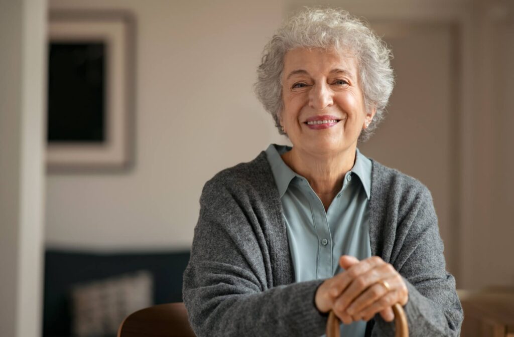 a senior smiles, holding a cane